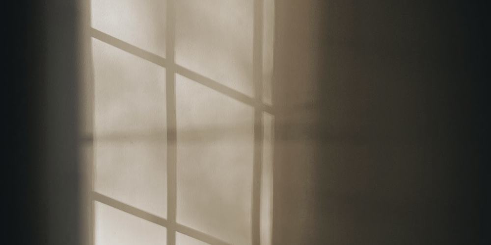 Window light falling across a plain interior wall